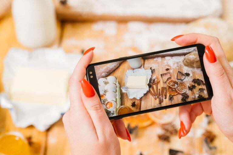 Przepis kulinarny online Widok z góry ekranu smartfona ze składnikami ciasta Pani rejestrująca kroki przy robieniu ciastek