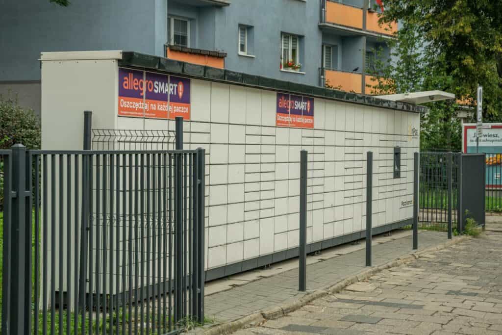 Outdoor parcel locker in Wroclaw, with Allegro Smart advertisement, near residential buildings.
