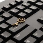 Close-up of an ornate vintage key placed on a modern computer keyboard.