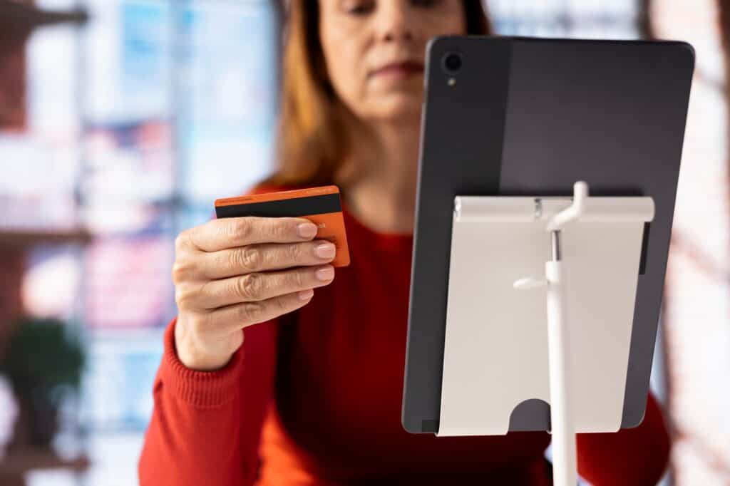 Przypadkowa kobieta trzymająca kartę do sprawdzenia salda finansowego przed zakupem czegoś