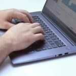Close-up of hands typing on a laptop displaying data analysis charts, perfect for business contexts.